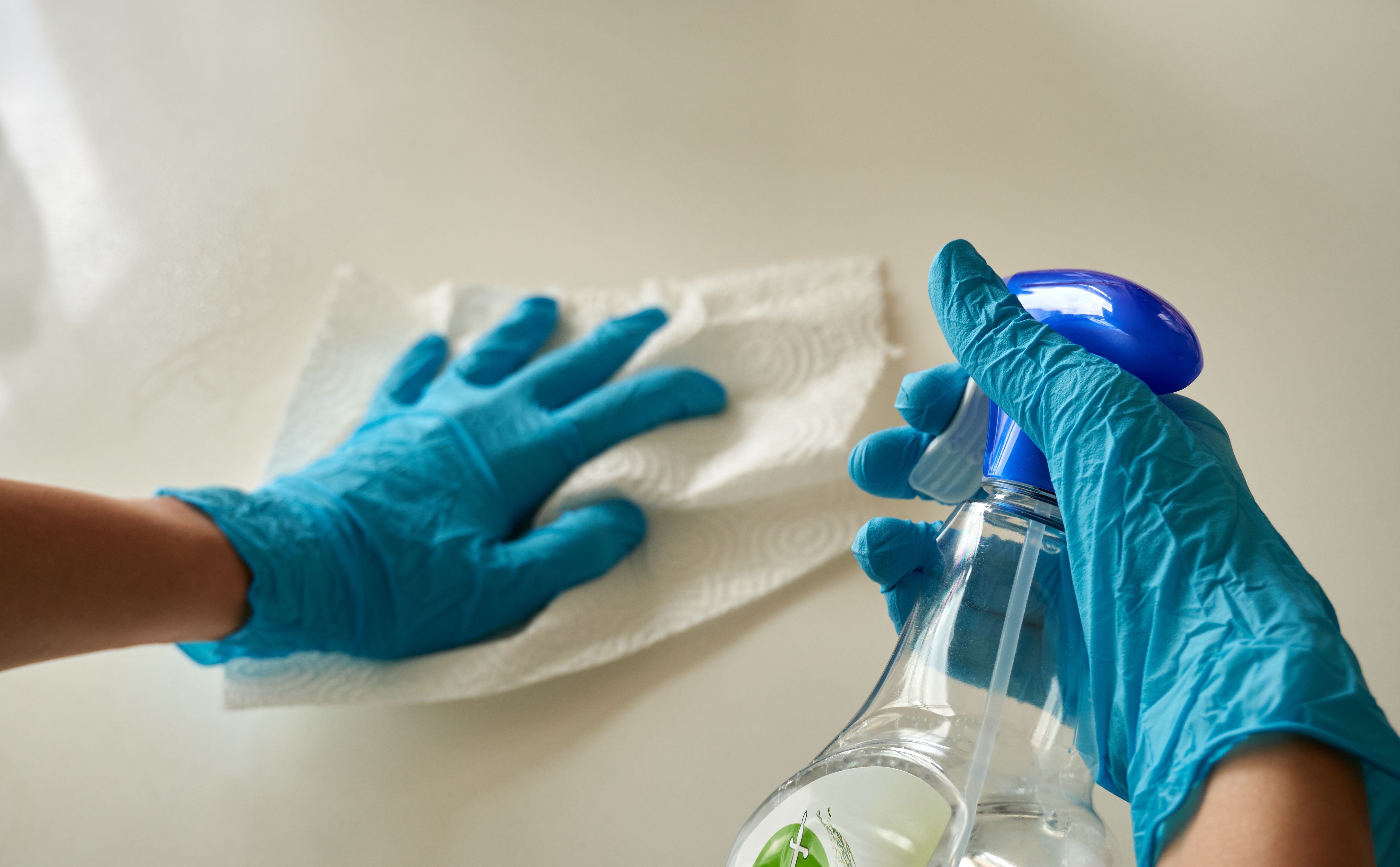 Cleaner wiping down a kitchen countertop